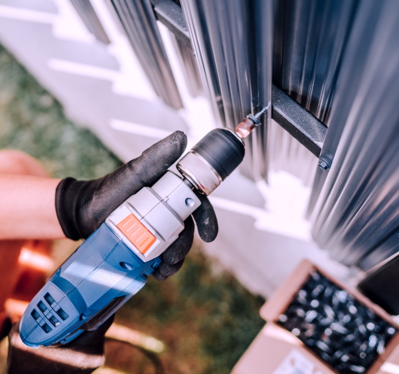 working with an electric screwdriver on the aluminum fence ronkonkoma ny
